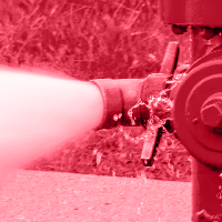 A monochromatic red image of a fire hydrant spraying water.