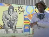 Artist Phillip Saunders stands in front of his mural.