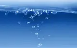 Bubbles coming to the surface of blue water.