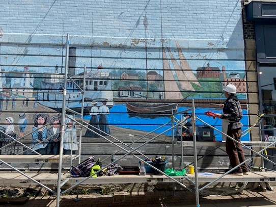 Lambertus De Graaf works to refresh The Kincardine Harbour mural in downtown Kincardine.